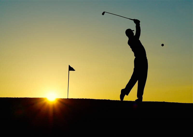 silhouette-of-man-playing-golf-at-sunset